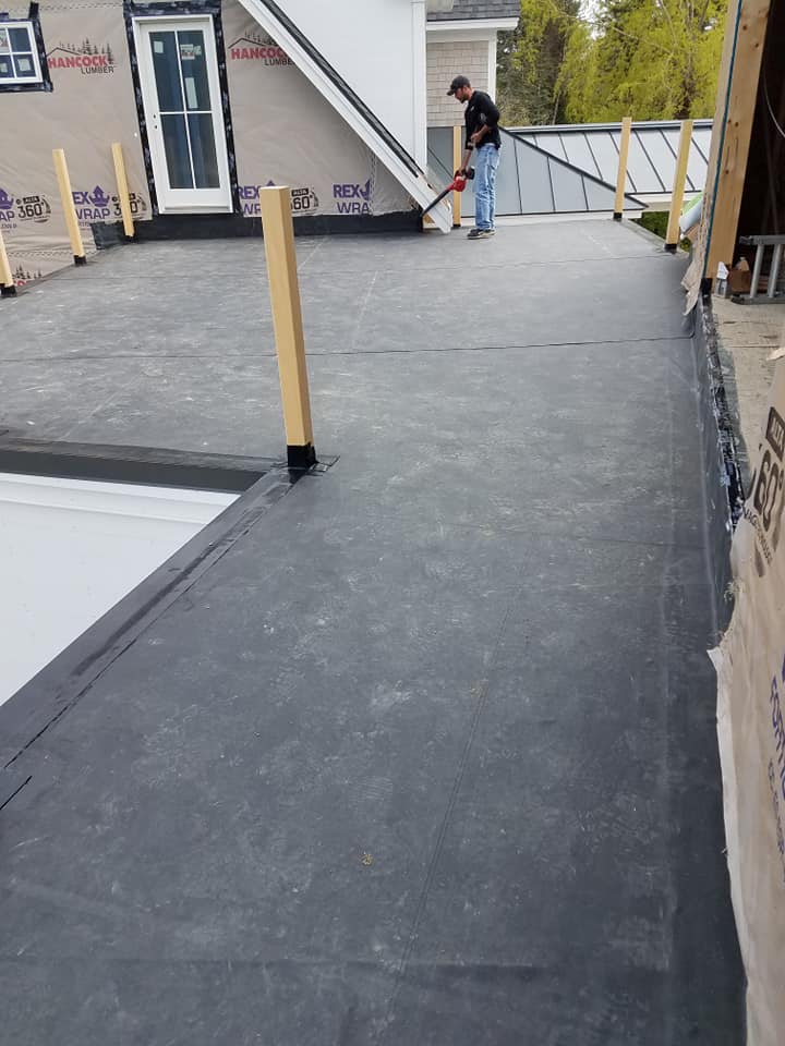 Installing rubber roofing on flat portion of roof