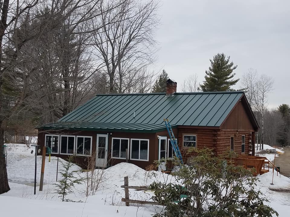 Green seam metal roofing on log cabin