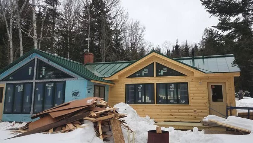 Sleek green metal roofing on newly constructed log home